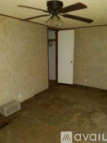 A room with a ceiling fan and a door.