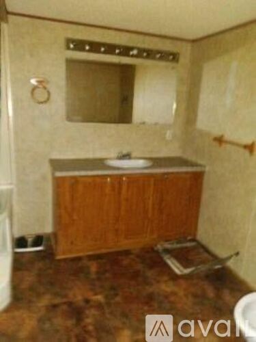 A bathroom with a brown counter top and a white sink.