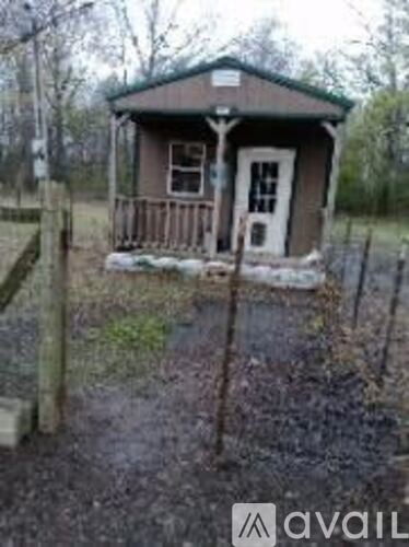 A small brown house with a white door and a porch.