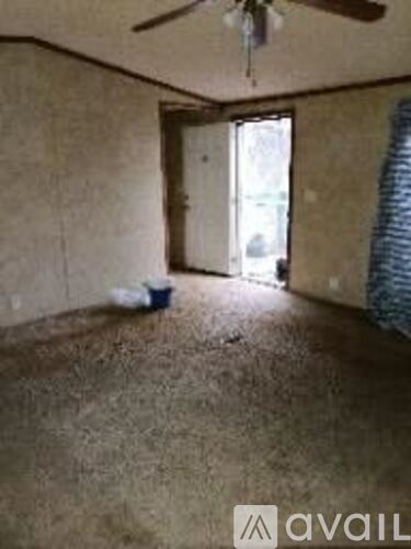 A room with a ceiling fan and a window with blinds.