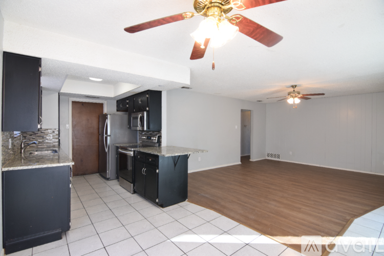 A kitchen with a black fridge and a black stove top oven.