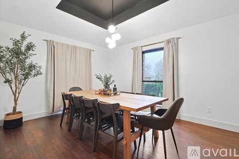 A dining room with a wooden table and chairs.