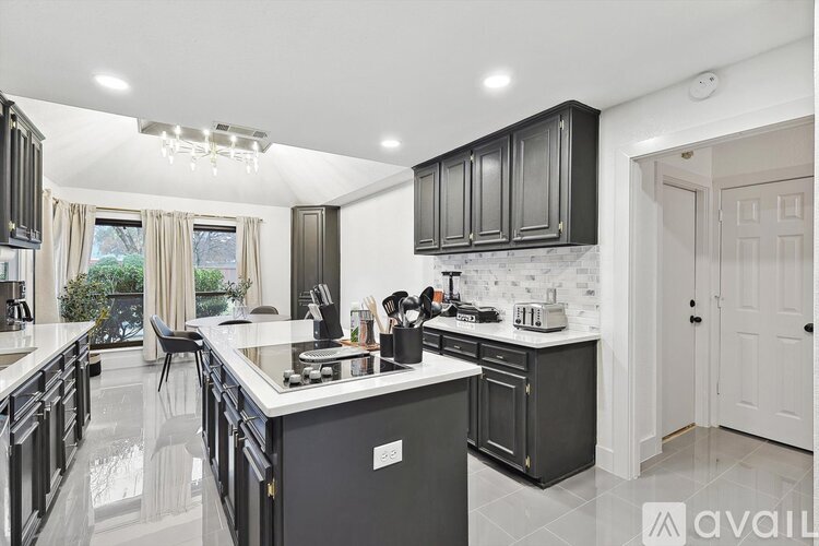 A modern kitchen with black cabinets and a white countertop.