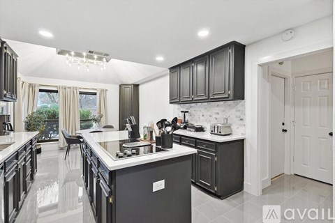 A modern kitchen with black cabinets and a white countertop.