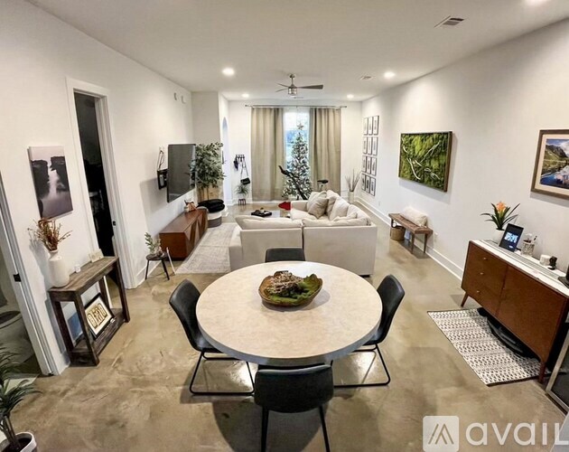 A living room with a dining table and chairs, a couch, and a television.