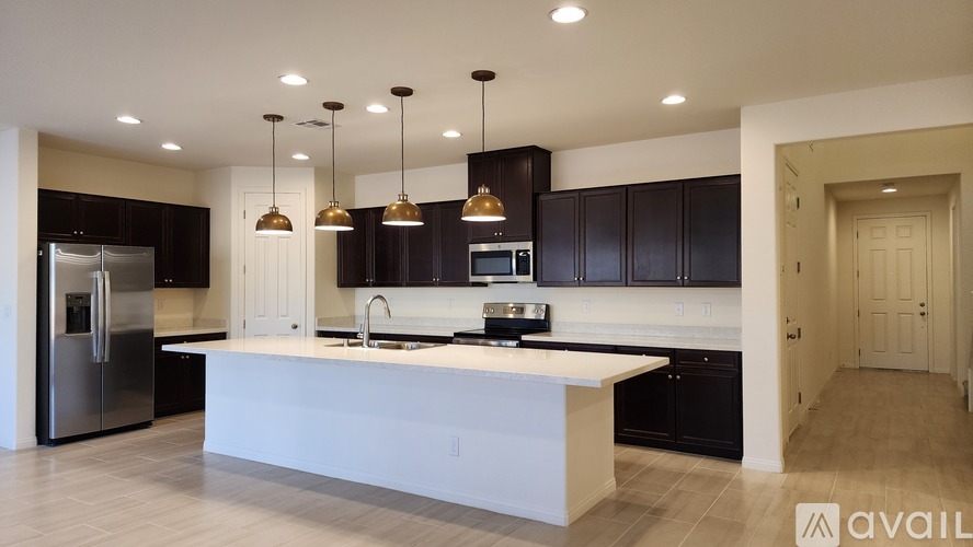A modern kitchen with a white island and black cabinets.