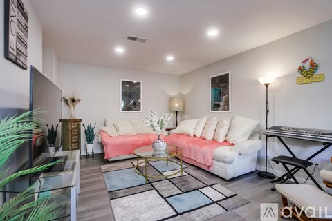 A living room with a white couch and a glass table.