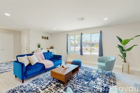 A living room with a blue sofa and a wooden coffee table.