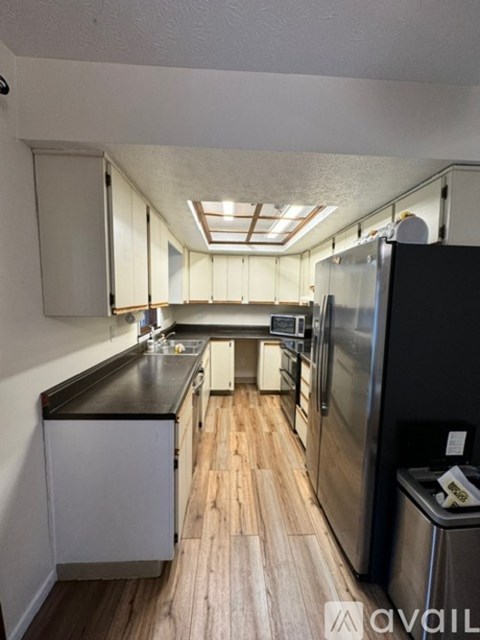 A kitchen with a black countertop and stainless steel appliances.