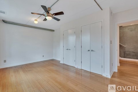 A room with a ceiling fan and three white doors.
