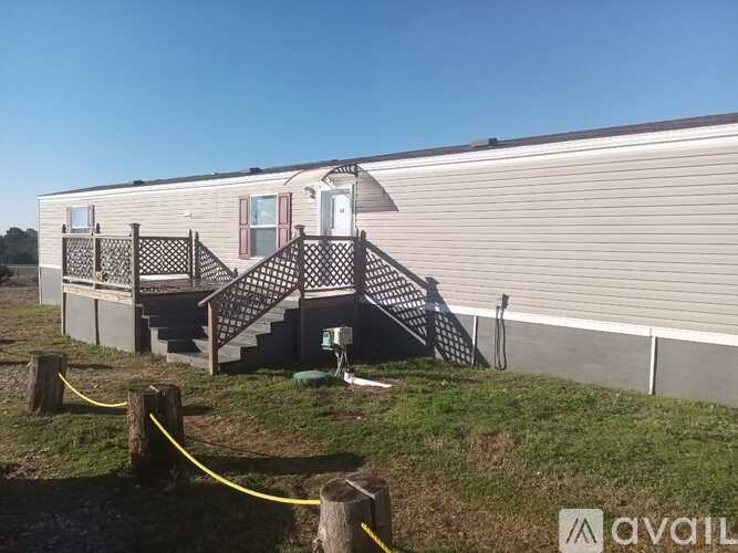 A mobile home with a front porch and stairs leading up to the door.