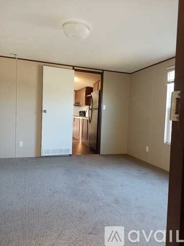 A room with a carpeted floor and a doorway leading to another room.