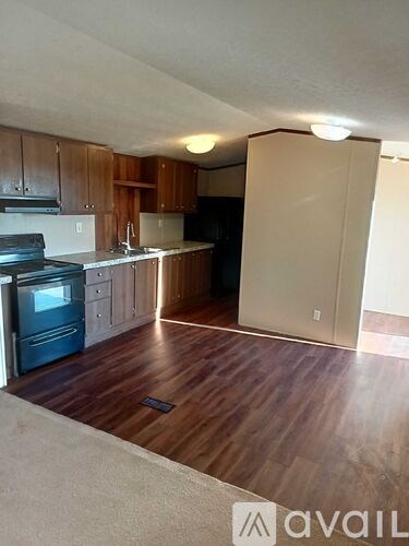A kitchen with wooden cabinets and a black stove top oven.