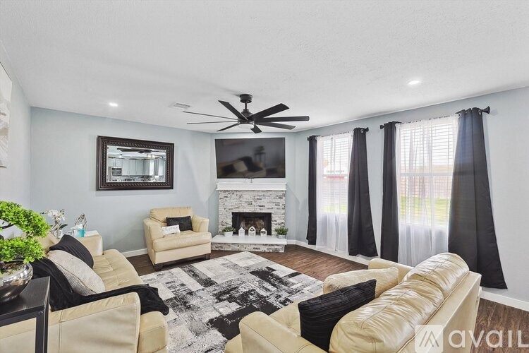 A living room with a fireplace, two couches, and a rug.