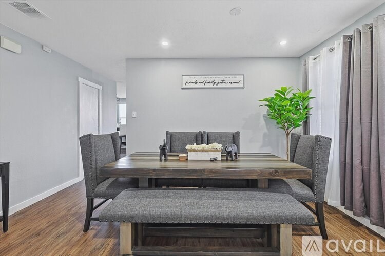 A dining room with a wooden table and chairs.