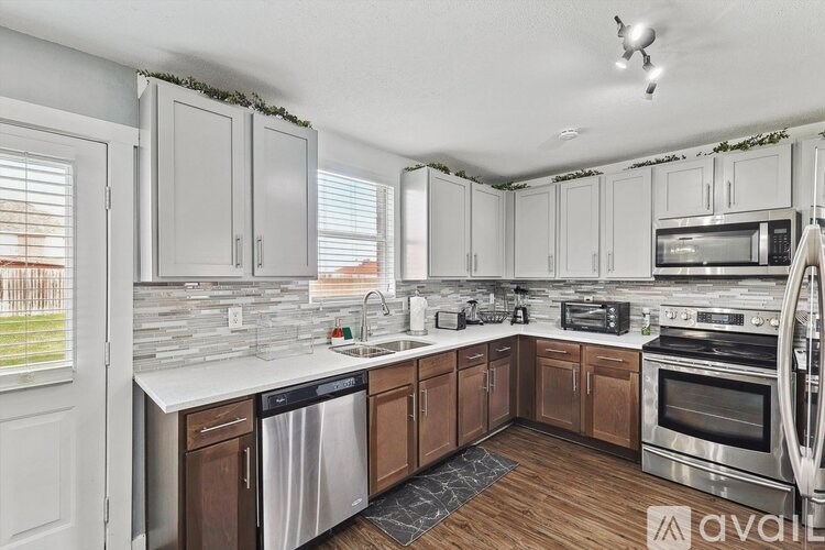 A kitchen with white cabinets and a stainless steel dishwasher.
