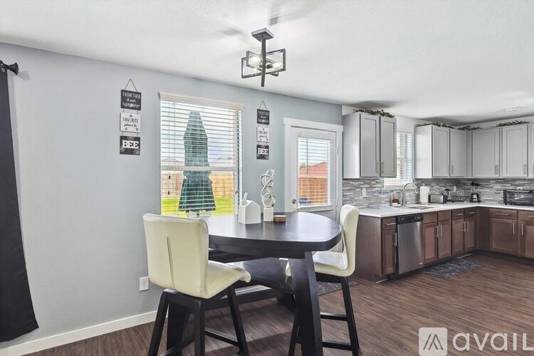 A kitchen with a table and chairs in front of a window.