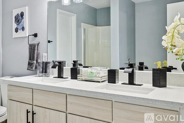 A bathroom with a white countertop and a large mirror above it.