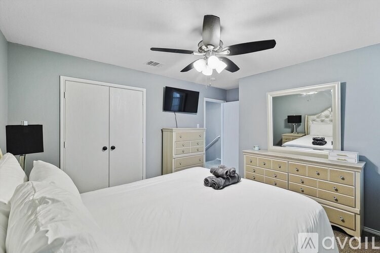 A bedroom with a bed, dresser, and mirror.