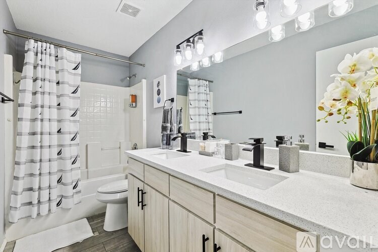 A bathroom with a white toilet, a sink, and a shower with a white curtain.