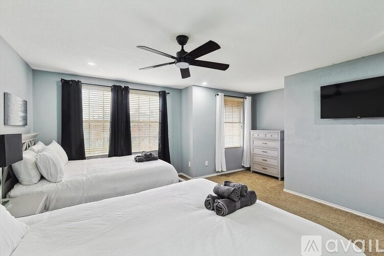 A bedroom with a large bed and a ceiling fan.
