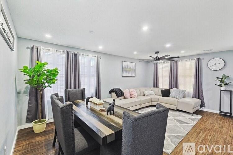 A modern dining room with a wooden table and grey chairs.