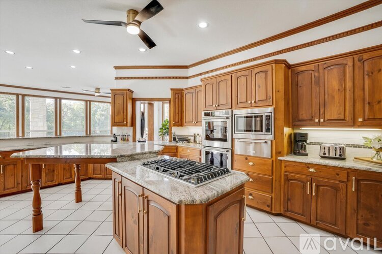 A kitchen with wooden cabinets and a marble countertop.