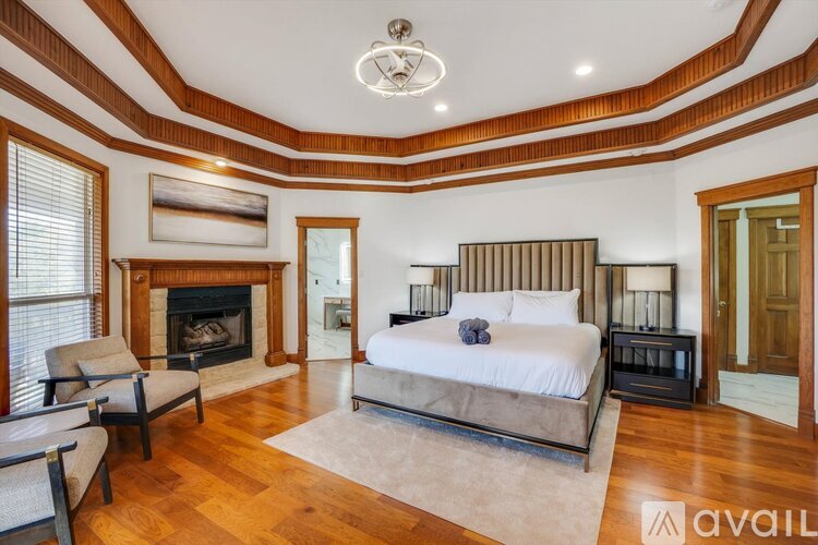 A bedroom with a large bed and a fireplace.