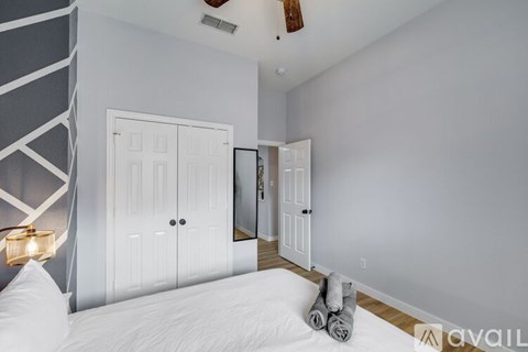 A bedroom with a large bed and a mirror on the wall.
