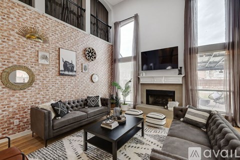 A living room with a grey couch and a fireplace.