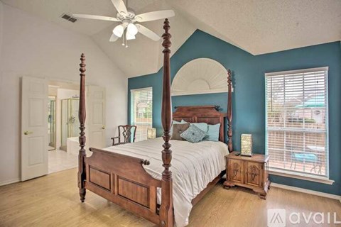 A bedroom with a large bed and a ceiling fan.