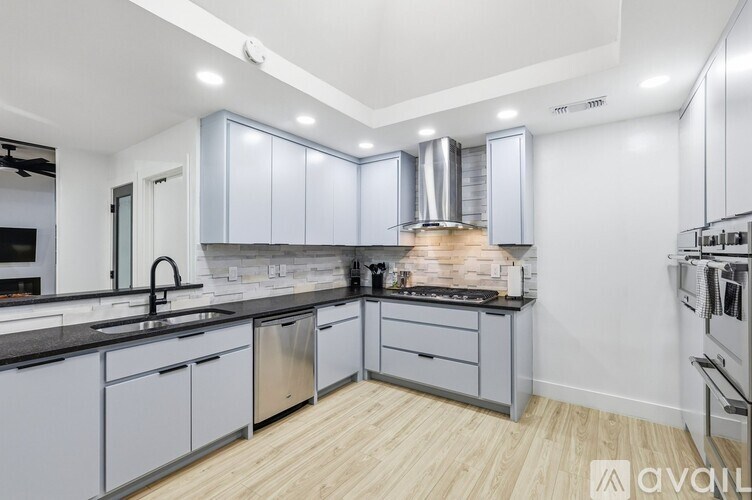 A bedroom with a white bed and a black and white patterned rug.