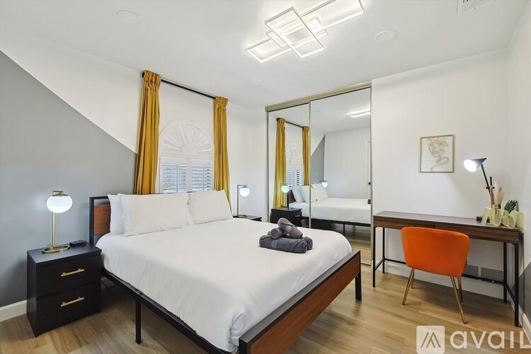 A bedroom with a bed, desk, and chair.