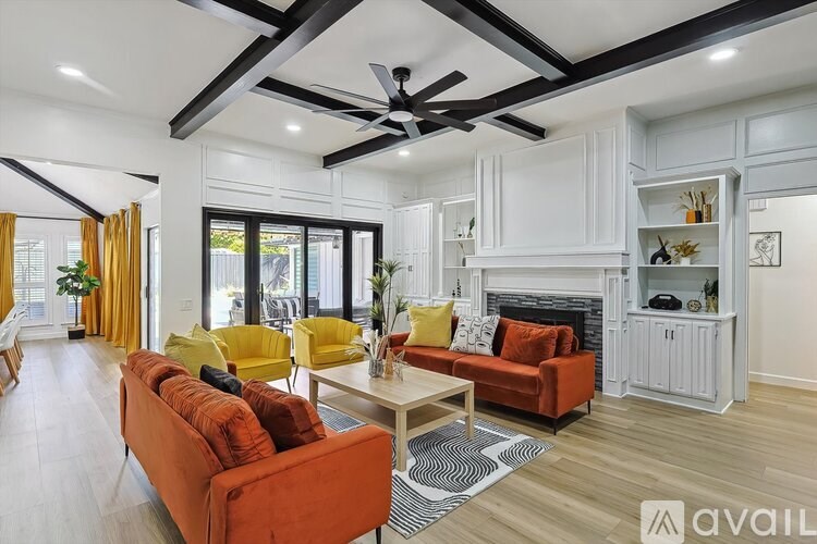 A living room with a red couch and a fireplace.