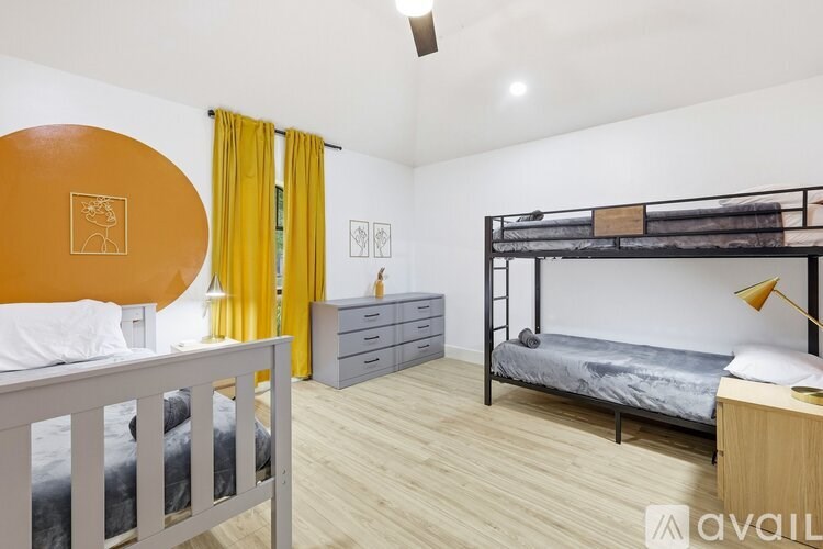 A bedroom with a white bed and a mirror on the wall.