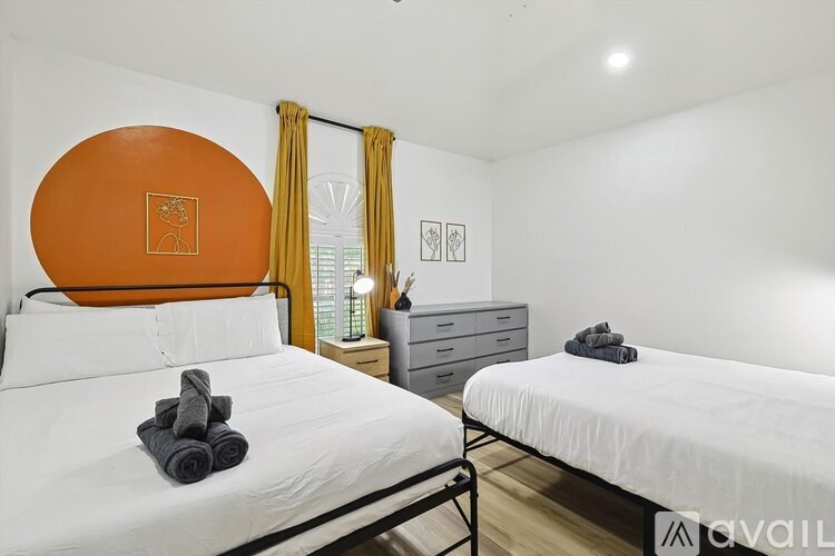 Two beds with towels on them in a room.