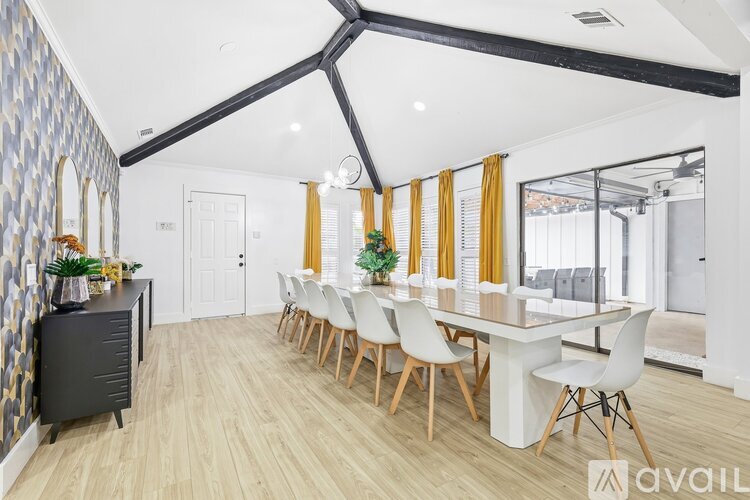 A modern dining room with a long table and chairs.