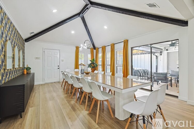 A modern dining room with a long table and chairs.
