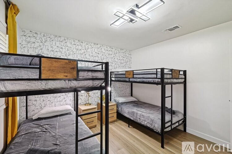 Two bunk beds in a room with white walls and wooden floors.