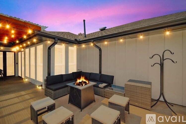 A patio with a fire pit and seating area.
