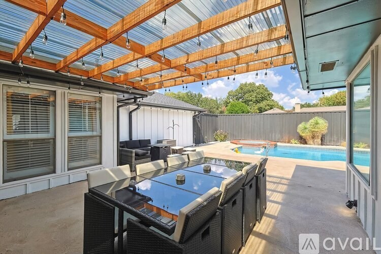A patio with a pool table and a hot tub.
