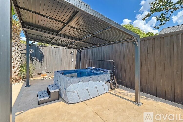 A hot tub is under a covered patio.