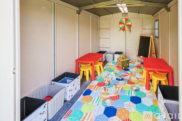 A room with a colorful carpet and several chairs and tables.