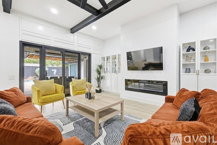 A living room with a red couch and a wooden floor.