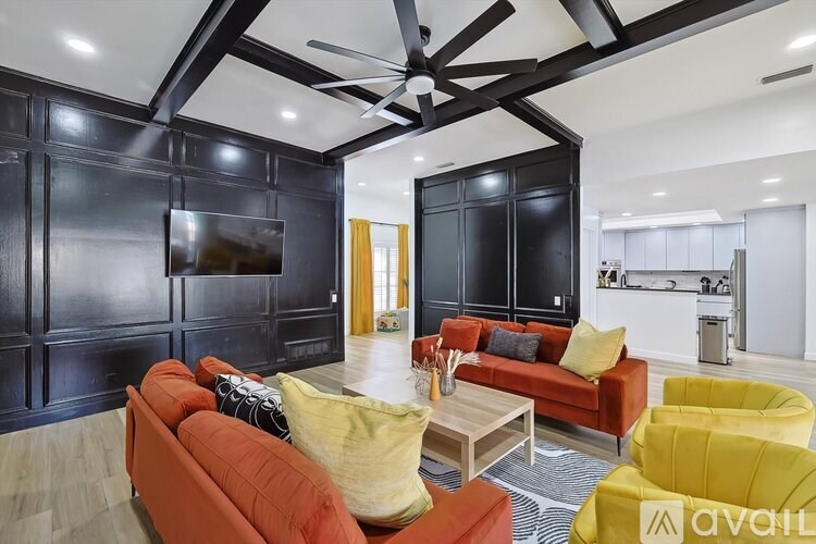 A living room with a red couch and yellow chairs.