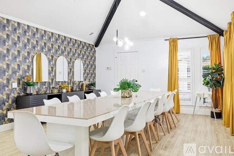 A modern dining room with a long table and chairs.