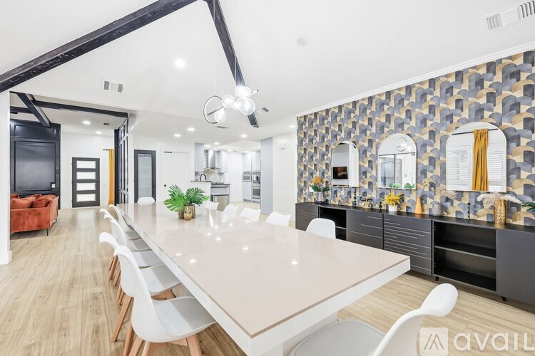 A modern kitchen with a stone backsplash and wooden flooring.