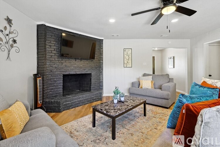 A living room with a fireplace and a TV above it.