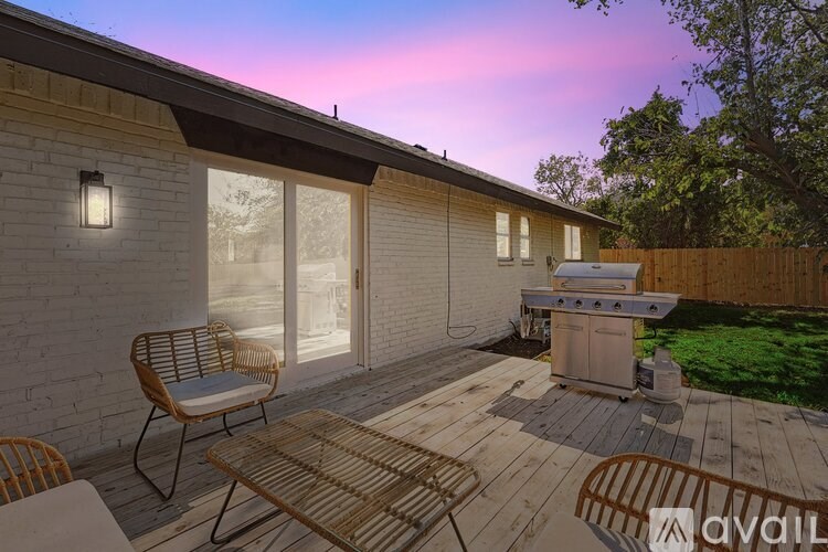A patio with a table and chairs is set up outside a house.