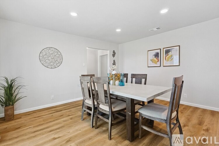 A dining room with a white table and chairs.